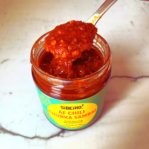 Photo of a big scoop of Sibeiho AF Chili Chunka Sambal coming out of the jar. Sibeiho Sambals are 100% natural and based on family recipe.  This Vegan Sambal is garlicky with touch of heat. Singapore Sambal Singaporean Food Hainanese Chicken Rice as featured in Bon Appetit & Eater. 